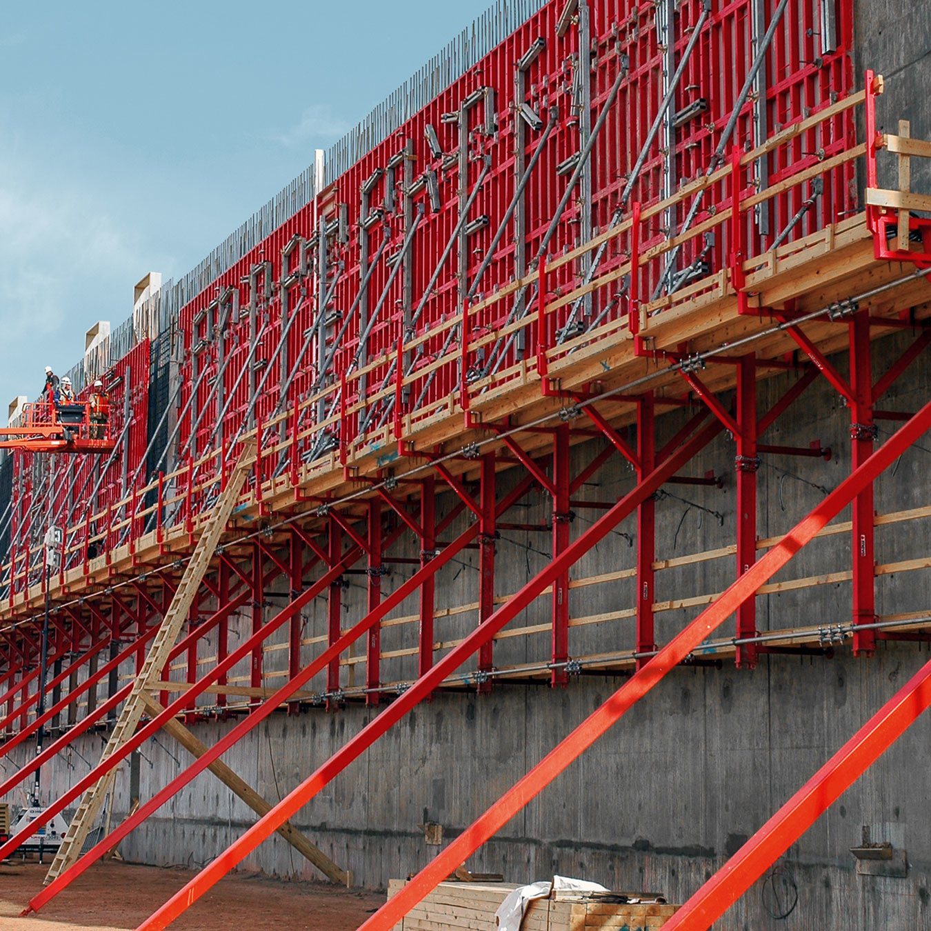 Climbing scaffolding and braces supporting a concrete wall