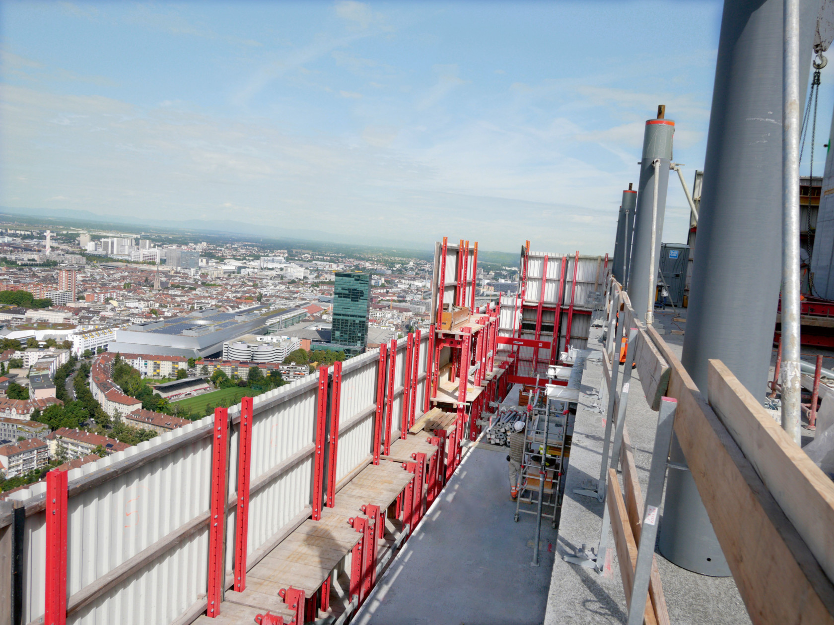 Climbing formwork safety screens atop skyscraper