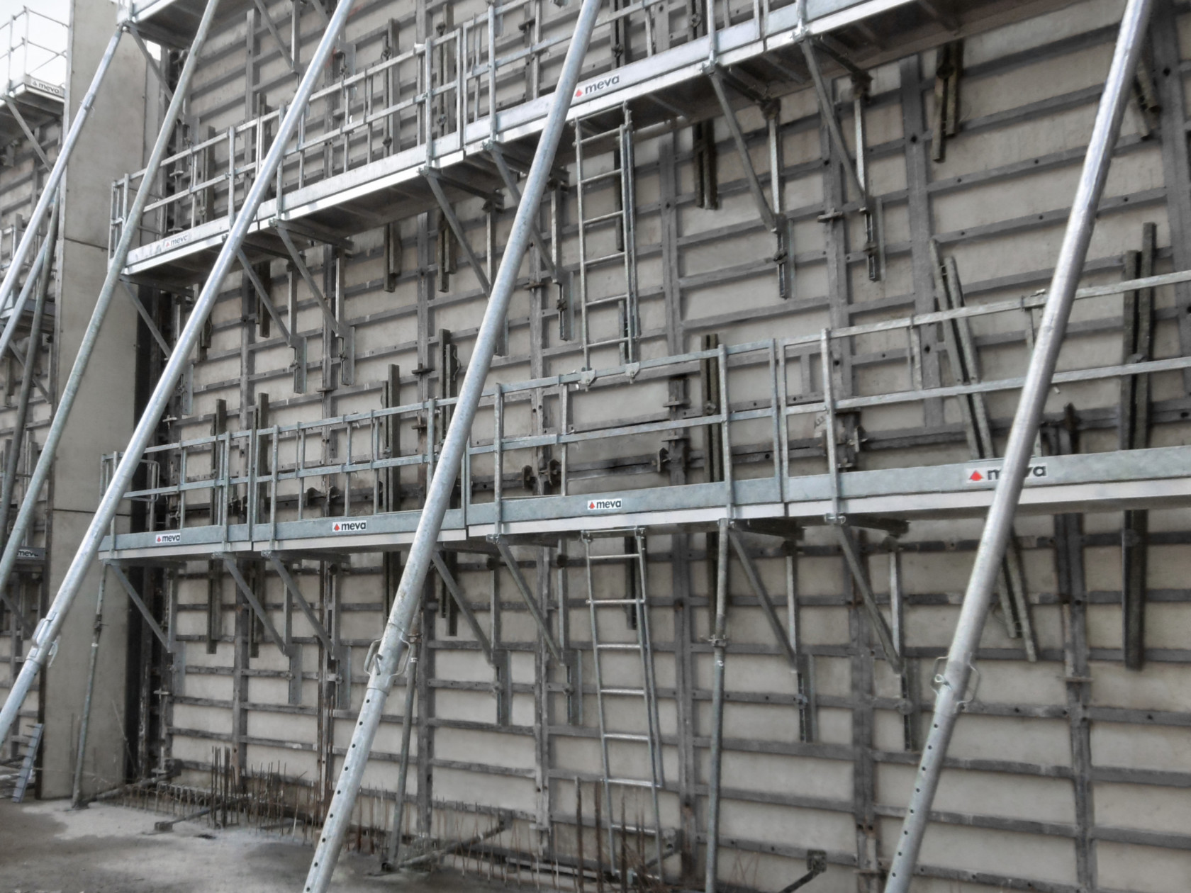 Tall wall formwork held in place with support systems and safety accessories